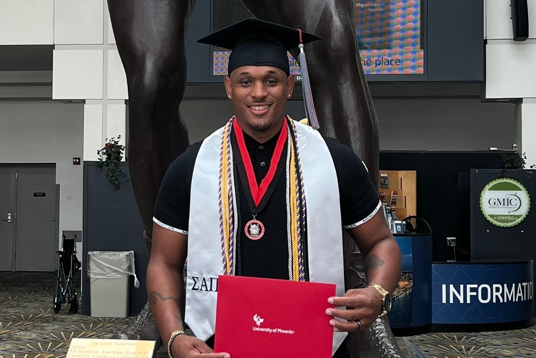 University of Phoenix NSLS member graduating and showing off his NSLS graduation regalia